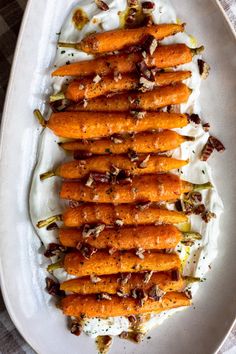 carrots with yogurt and nuts on a white plate