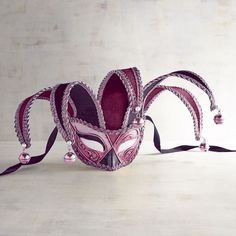 a masquerade mask with pink and purple decorations