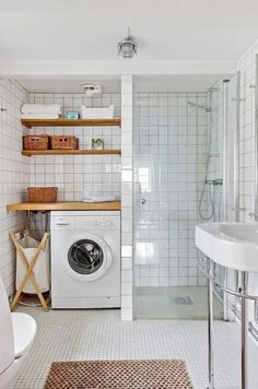 a washer and dryer in a bathroom with white tiles on the walls,