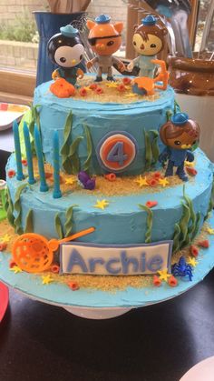 a three tiered cake with cartoon characters on it