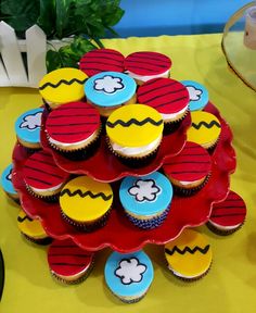 cupcakes are arranged in the shape of a tree on a yellow tablecloth