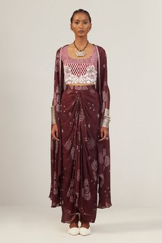 Rosewood maroon cape with all over floral bandhani print, slit sleeves and thread checkered embroidered border. Paired with printed draped skirt with front pleated details, round neck padded bustier with checkered, swirl pattern, mirror, thread embroidery and crystal highlights.
Components: 3
Pattern: Printed and Hand Embroidered
Type Of Work: Floral Bandhani Print, Thread, Crystals and Mirror Work
Neckline: Cape: Open, Bustier: Round Neck
Sleeve Type: Cape: Slit Sleeves, Bustier: Sleeveless
Fab Bandhani Print, Hand Accessories, Embroidered Border, Draped Skirt, Luxury Sale, Thread Embroidery, Mirror Work, Swirl Pattern, Set For Women