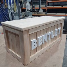 a wooden bench with the word bentley written on it's sides in white letters