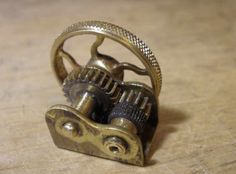 an old brass clock mechanism on a wooden table