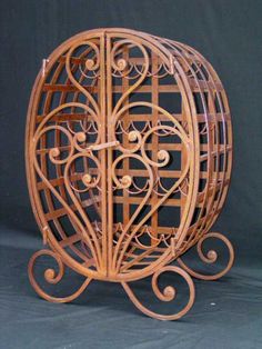 a decorative wooden object with intricate carvings on it's sides and arms, in the shape of a birdcage