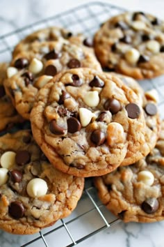 chocolate chip cookies on a cooling rack with white and dark chocolate chips in the middle