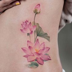 a woman's lower back tattoo with pink flowers