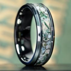 a black ring with green and white marble inlayed to the inside of it