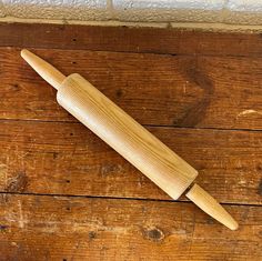 a wooden rolling pin sitting on top of a wooden floor