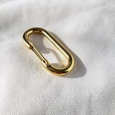 a gold metal ring on top of a white cloth with a small hole in the middle