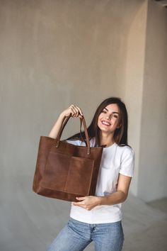 This handmade women tote bag is produced of cowhide leather. It has one pocket inside. The bag has a high-quality zipper that secures your belongings. It holds the shape perfectly and you may be confident that your personal things like cell phone, tablet, lap-top are safe. This bag is simple, reliable, and durable. Its universal look allows to use the tote bag for various purposes. One may take the bag to the work, shopping, meeting, or walk and feel comfortable with it at any conditions. SIZE: On-the-go Tote Bag With Silt Pocket, Tote Shoulder Bag With Silt Pocket For On-the-go, Tote Weekender Bag With Pockets, Leather Bag With Silt Pocket For Everyday Use, Leather Tote Bag With Pockets, Tote Bags With Zipper, Personal Things, Best Tote Bags, Lap Top