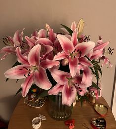 a vase filled with pink flowers on top of a wooden table