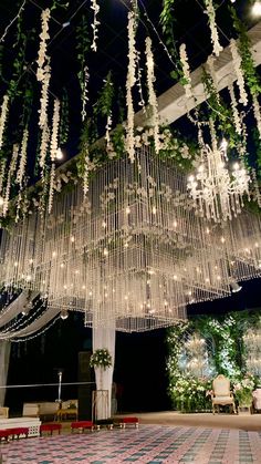 a large chandelier hanging from the ceiling in front of a room with tables and chairs