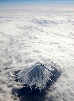 an aerial view of a mountain in the clouds