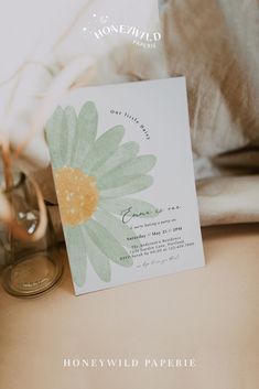 a card with a flower on it sitting next to a pair of shoes and some coins