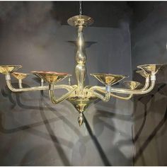 a chandelier with five lights hanging from it's sides in a room