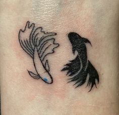 two black and white koi fish tattoos on the side of a woman's leg