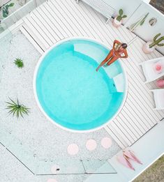 a woman standing in the middle of a swimming pool surrounded by pink and white decorations