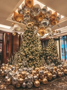 a large christmas tree with gold and silver ornaments