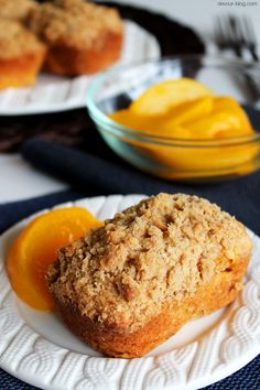 two plates with muffins and orange slices on them