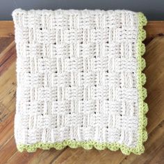 a green and white crocheted dishcloth on a wooden surface