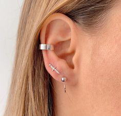 a close up of a person wearing a pair of ear piercings on their ears