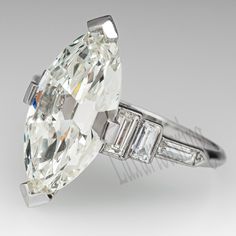 an oval cut diamond ring with baguetts and side stones