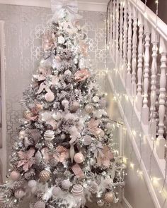 a white christmas tree with pink and silver ornaments