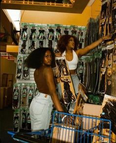 two women standing next to each other in front of a display of items at a store