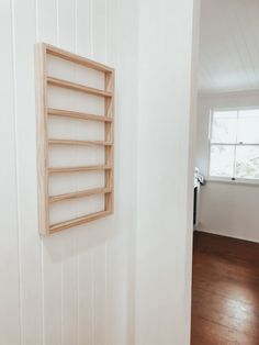 an empty room with a wooden shelf on the wall