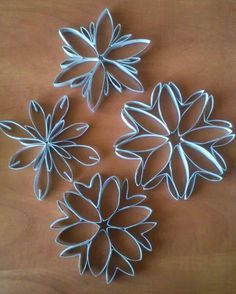 four metal flowers sitting on top of a wooden table