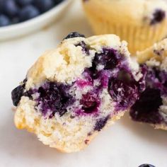 a blueberry muffin is cut in half and placed on top of another muffin