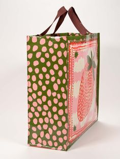 a green and pink shopping bag with polka dots on the bottom, featuring an image of a strawberry