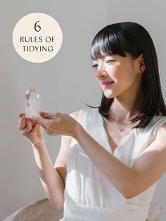 a woman holding a crystal ball in her hand with the words rules of tidying above it