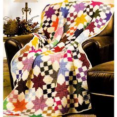 a colorful blanket sitting on top of a chair next to a lamp in a living room