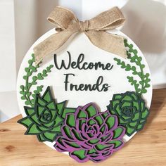 a sign that says welcome friends with succulents