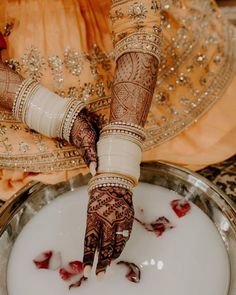 the bride is getting her hands painted with hendi and jewelry on her wedding day