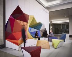 colorful chairs are arranged in the middle of a room with white walls and flooring