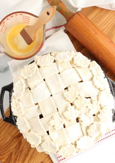 an uncooked pie sitting on top of a table next to a rolling pin