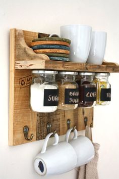 a wooden shelf with coffee mugs and spices on it, hanging from the wall