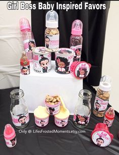 a table topped with bottles and jars filled with baby items next to a sign that says, girl boss baby inspired favors