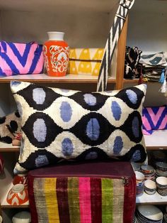 colorful pillows and vases on shelves in a store