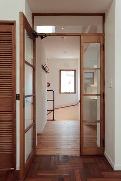 an open door leading into a room with wooden floors and white walls on both sides