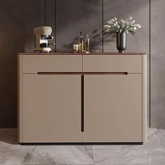 a sideboard with two vases and flowers on it in front of a gray wall