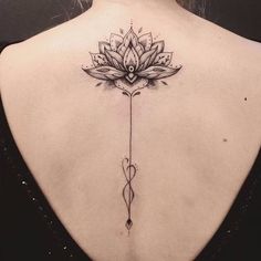 the back of a woman's neck with a lotus tattoo on it