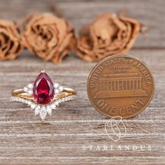 a close up of a coin and a ring with a red stone in the middle