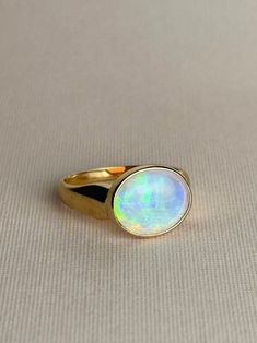 Introducing our Rainbow Opal Signet Ring, a timeless signet style design featuring a light purple opal that emits all colors of the rainbow with a distinct pattern. This ring is a statement piece that is sure to elevate any ensemble with its eye catching colors and design.  Opal originated in Coober Pedy, Australia 3g of 18 karat gold Opal measuring approx. 9.5 x 11.5mm Ring size US 6 Should you require this ring to be resized, please contact us or send an email to ParissJewellery@outlook.com Opal Ring Thick Band, Coober Pedy Australia, Purple Opal, Rainbow Opal, Coober Pedy, Crystal Opal, Opal Crystal, Eye Catching Colors, Light Purple