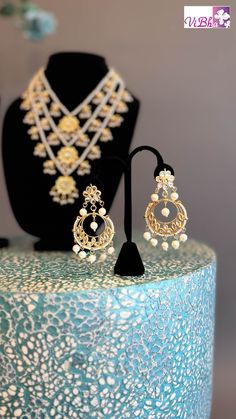 Indulge in luxury with our Pearl Kundan Polki Satlada Style set, complete with a stunning maang tikka and delicate chandbali earrings. Handcrafted with exquisite pearl and Kundan stones, this set exudes elegance and sophistication, making it a must-have for any special occasion. Elevate your look with this exclusive piece. Chandbali Jewelry For Diwali Reception, Diwali Chandbali Jewelry Sets With Latkans, Tilla Chandbali Bridal Sets For Celebration, Chandbali Meenakari Jewelry For Reception, Bollywood Style Tilla Chandelier Earrings For Reception, Kundan Chandbalis Hand Set For Reception, Kundan Chandbalis With Hand Set Details For Reception, Kundan Chandbalis For Reception With Hand Set, Hand Set Kundan Chandbalis For Receptions