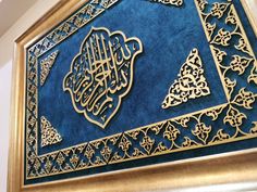 an intricately designed blue and gold frame with arabic calligraphy on the front side