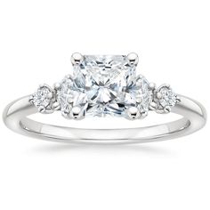 an engagement ring with a princess cut diamond in the center and side stones on each band